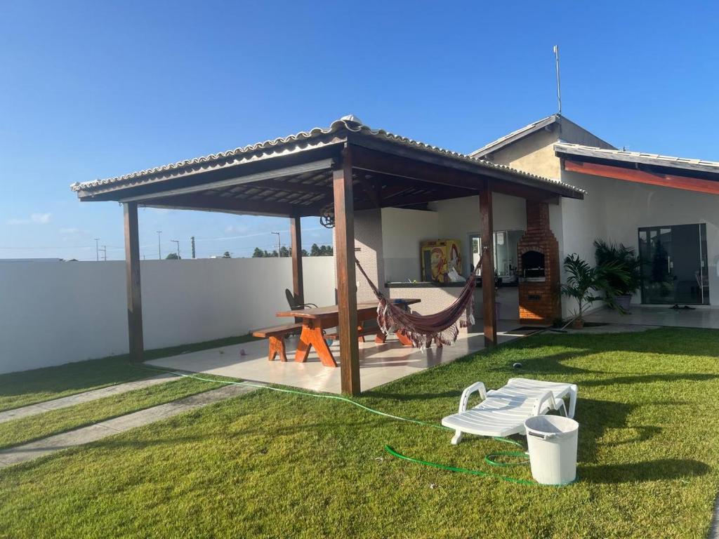 ein Pavillon mit Tisch und Stühlen in einem Hof in der Unterkunft CONDOMINIO MERIDIEN PRAIA MAR Praia do Abais in Estância