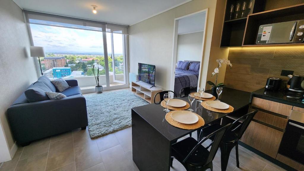 een keuken en woonkamer met een tafel en stoelen bij Espectacular departamento 2D2B, súper ubicación, con estacionamiento in Los Ángeles
