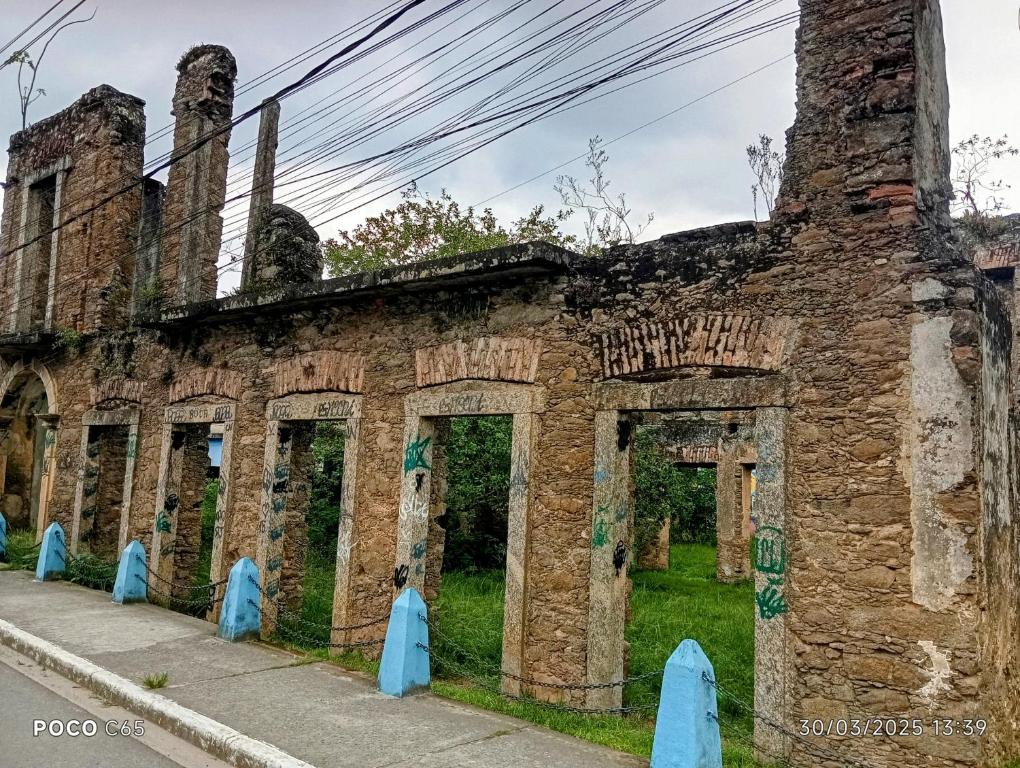 een oud bakstenen gebouw aan de kant van de weg bij Pousada suite Praia in Mangaratiba