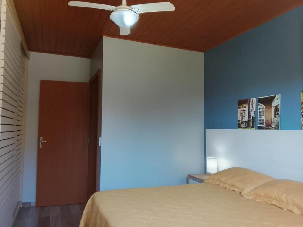 ein Schlafzimmer mit einem Bett und einem Deckenventilator in der Unterkunft A Casa Amarela - Morada dos Maçaricos - Tranquilidade próxima ao mar in Balneário Gaivotas
