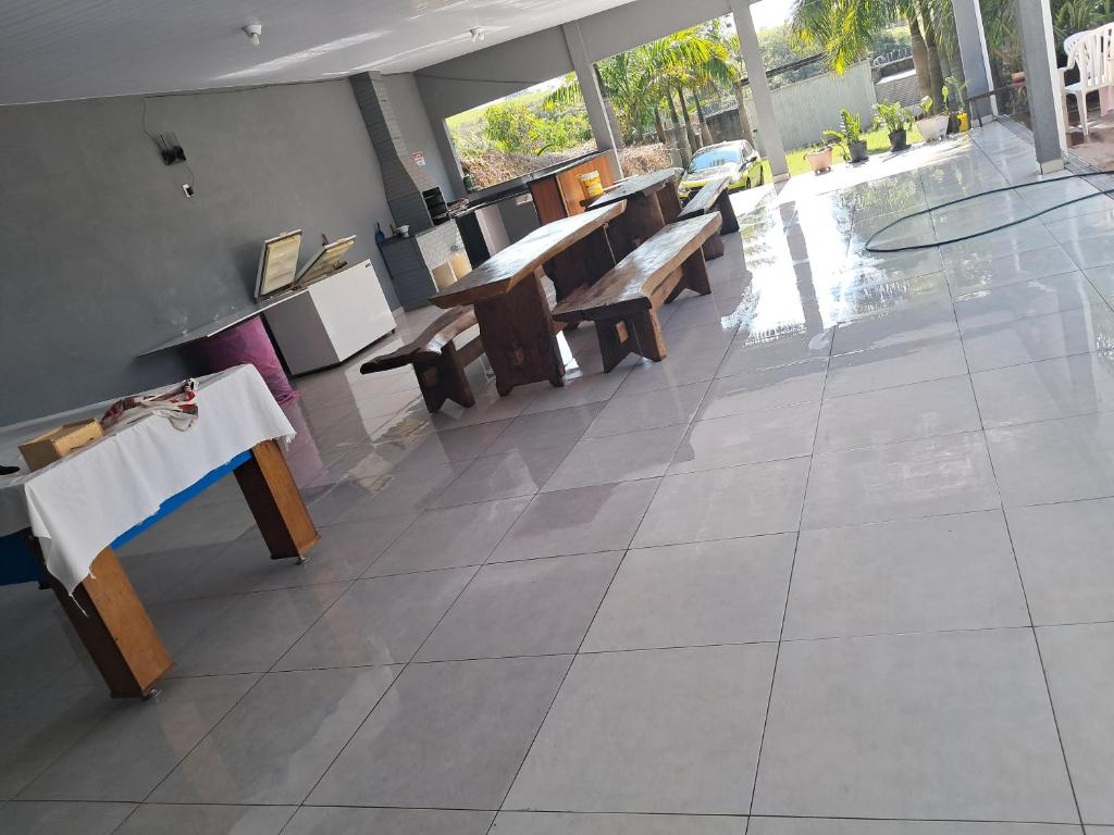 a restaurant with wooden tables and benches in a room at Meu Refúgio in Boituva