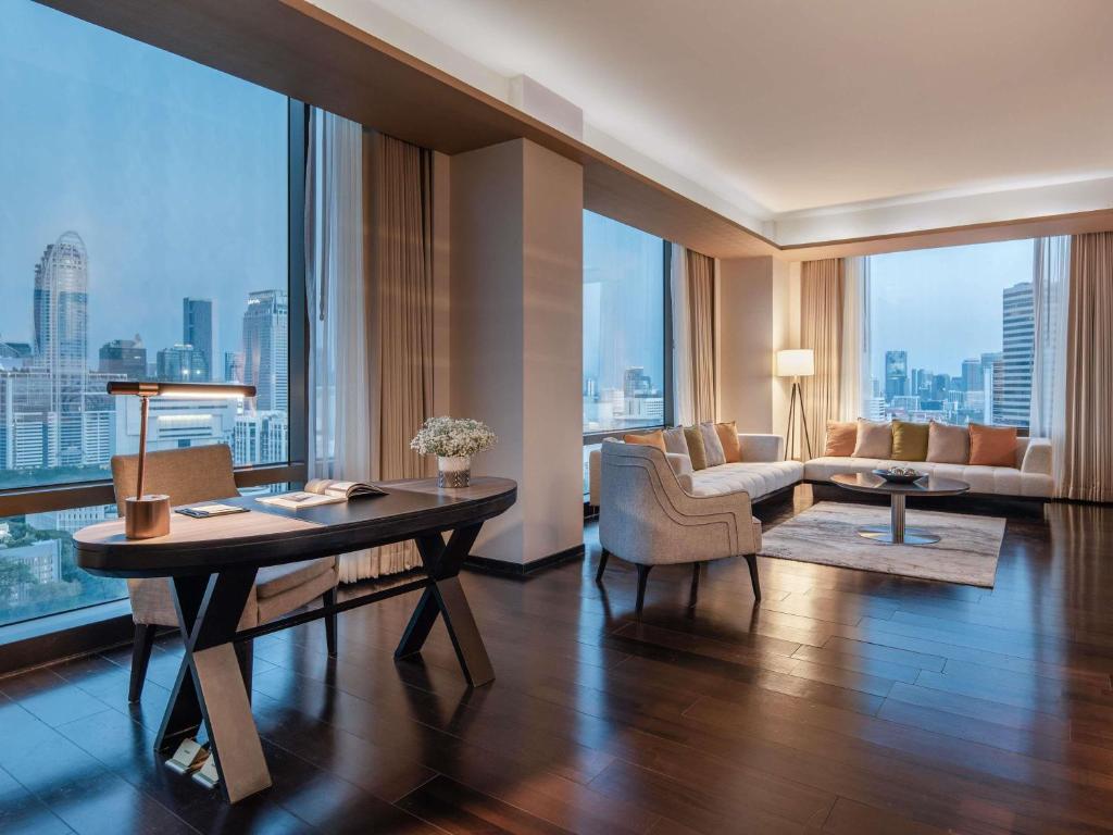 A dedicated writing desk sits beside corner windows overlooking Bangkok.