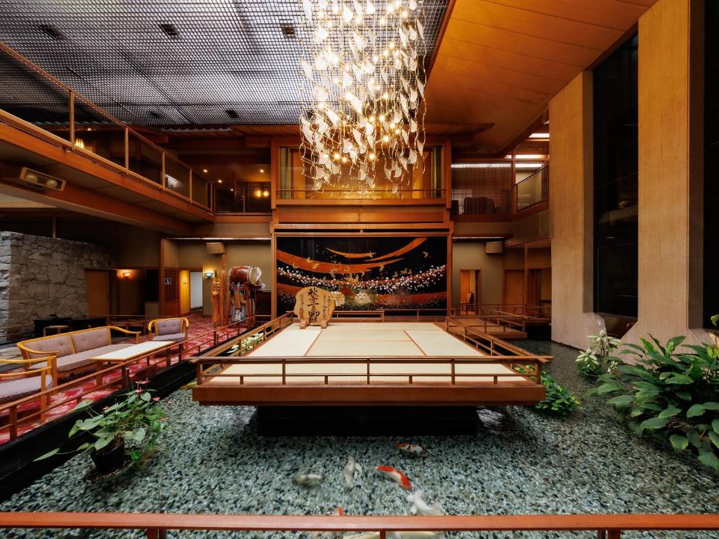 a large lobby with a chandelier and a stage at Hamanoyu in Suwa