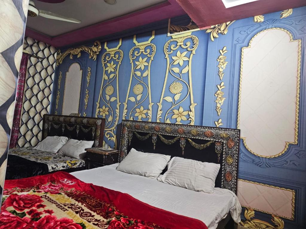 1 dormitorio con 1 cama y una pared azul y dorada en City Palace Hotel Lahore, en Lahore