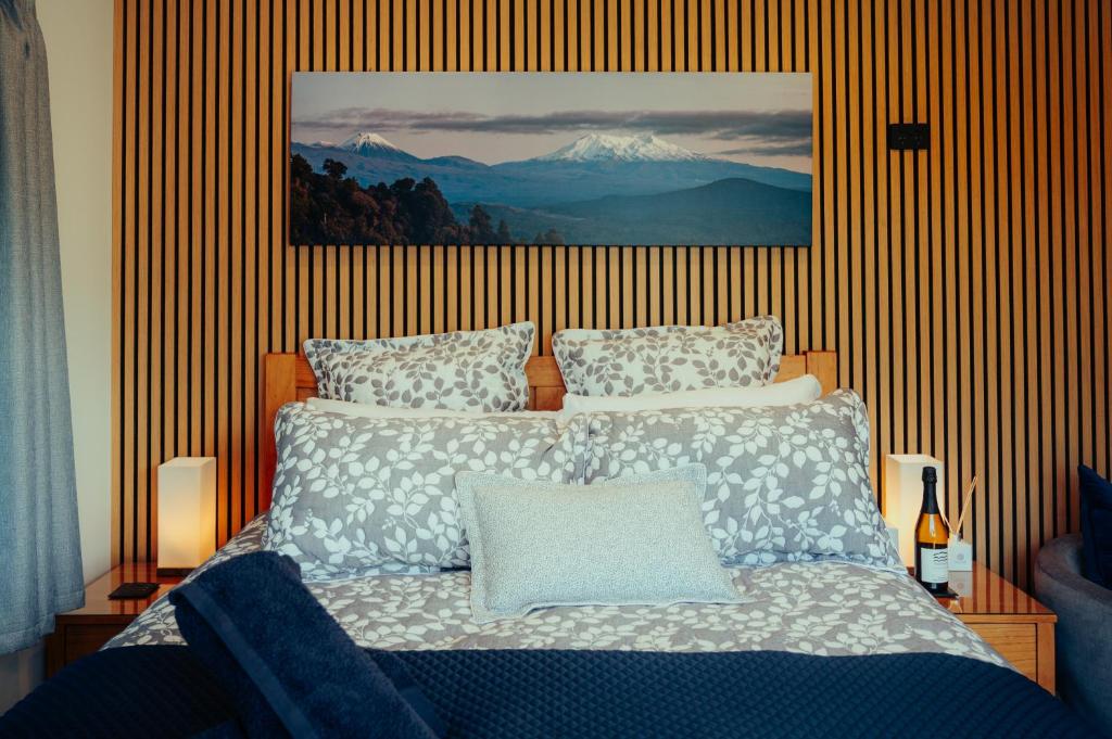 a bedroom with a bed with a picture on the wall at Two Rivers Ohakune - Boutique Bed and Breakfast in Ohakune