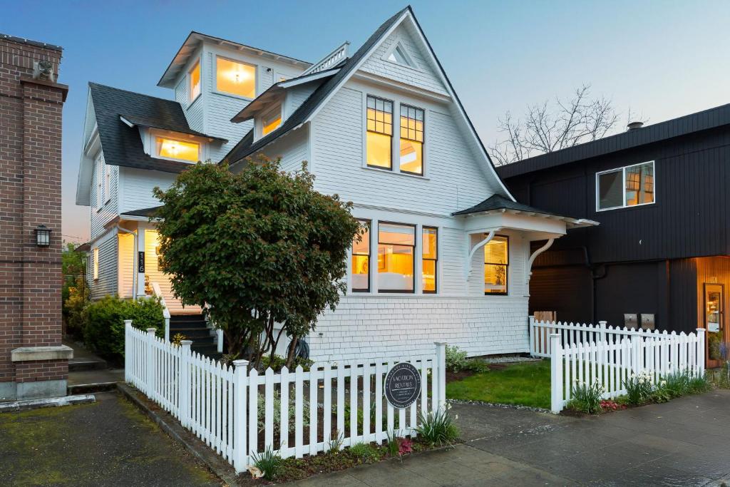 ein weißer Zaun vor einem Haus in der Unterkunft Home & Carriage House Views Dogs Welcome BBQ in Edmonds