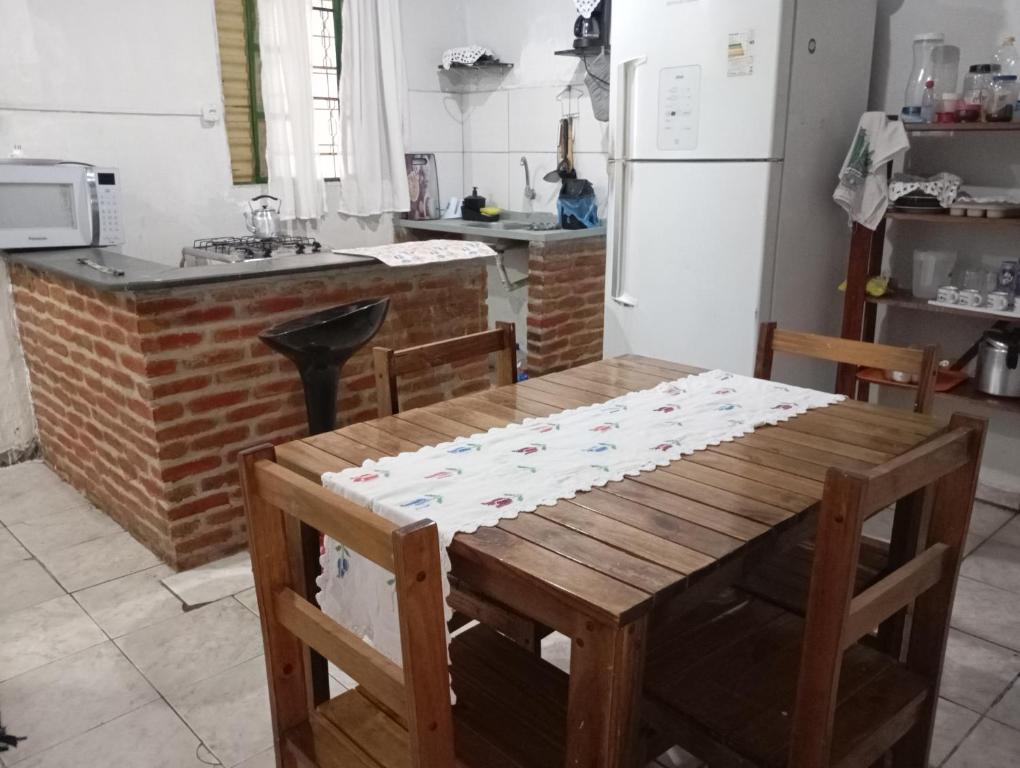 eine Küche mit Holztisch und Kühlschrank in der Unterkunft Casa quase frente a Rodoviária in Corumbá