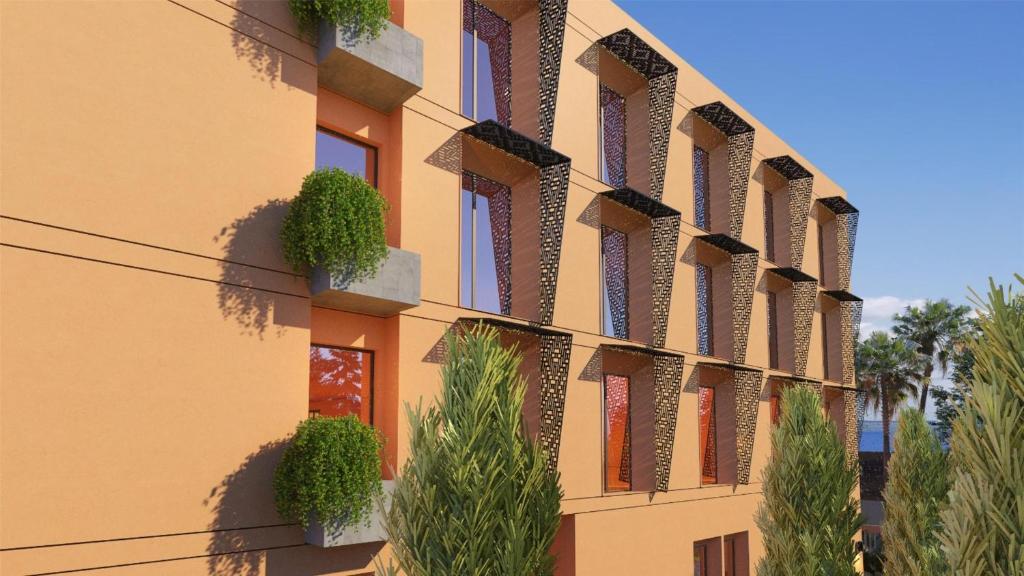 un bâtiment avec des plantes sur le côté dans l'établissement Hampton By Hilton Ben Guerir, à Benguerir