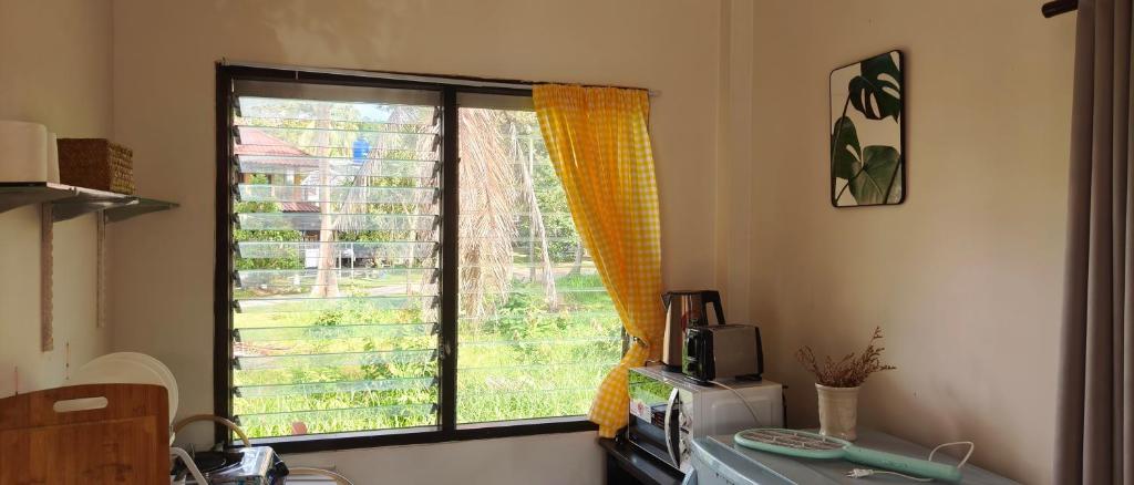 a kitchen with a window and a microwave at Secret Thai Peace No1 in Thongsala