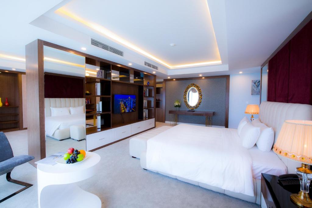 a bedroom with a large white bed and a couch at Muong Thanh Luxury Da Nang Hotel in Danang