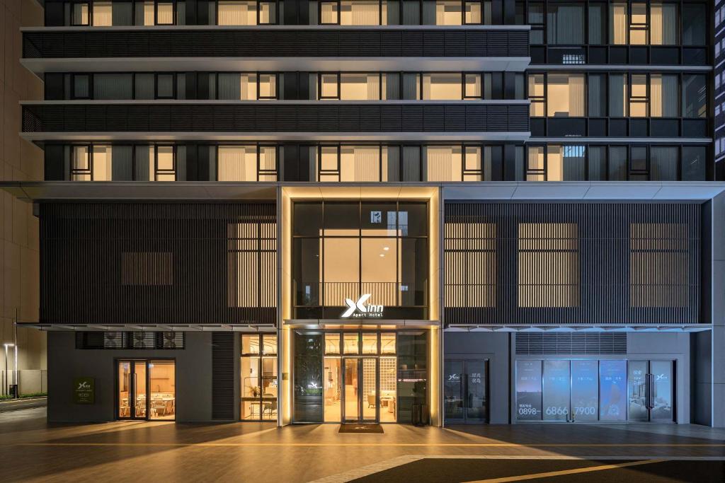 a tall building with a sign on the front of it at Dahua Group Xinn Hotel (Haikou West Coast Convention & Exhibition Center Branch) in Zhenhai