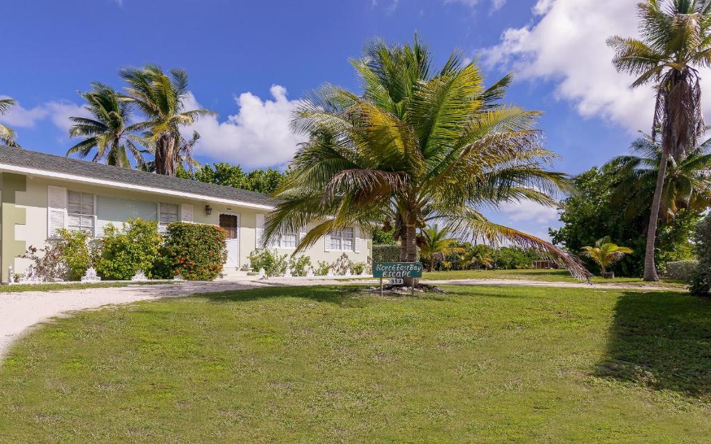 a house with palm trees in front of it at Northeast Bay Escape 