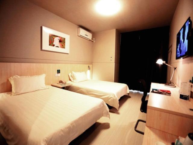 a hotel room with two beds and a television at Jinjiang Inn Kaifeng Longting Scenic Spot in Kaifeng