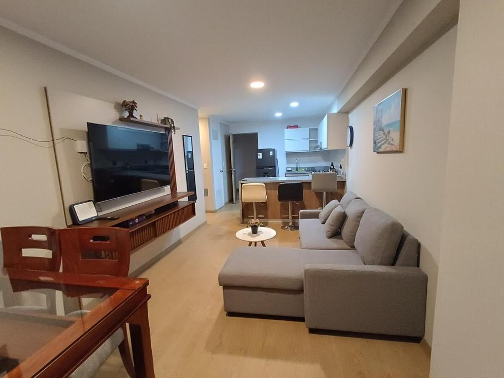 a living room with a couch and a flat screen tv at Apartment overlooking the water park in Lima
