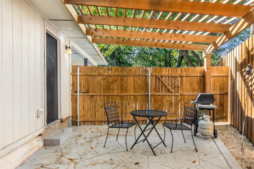 a patio with a table and chairs and a wooden pergola at 2bd 1bth Newly Renovated Home near Cowboys Stadium etc in Arlington