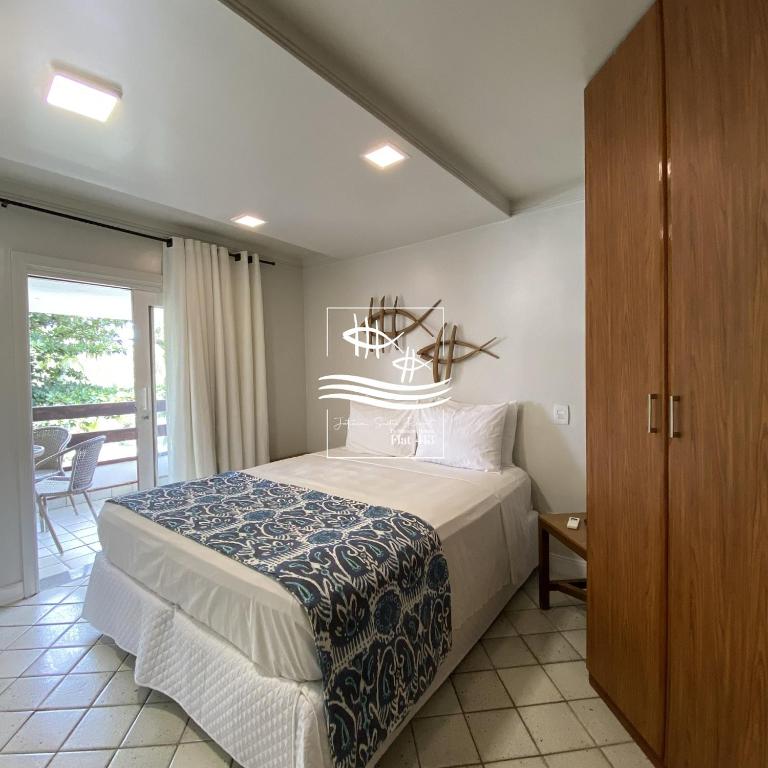a bedroom with a large bed and a balcony at Jatiúca Suítes Resort - Flat 413 in Maceió