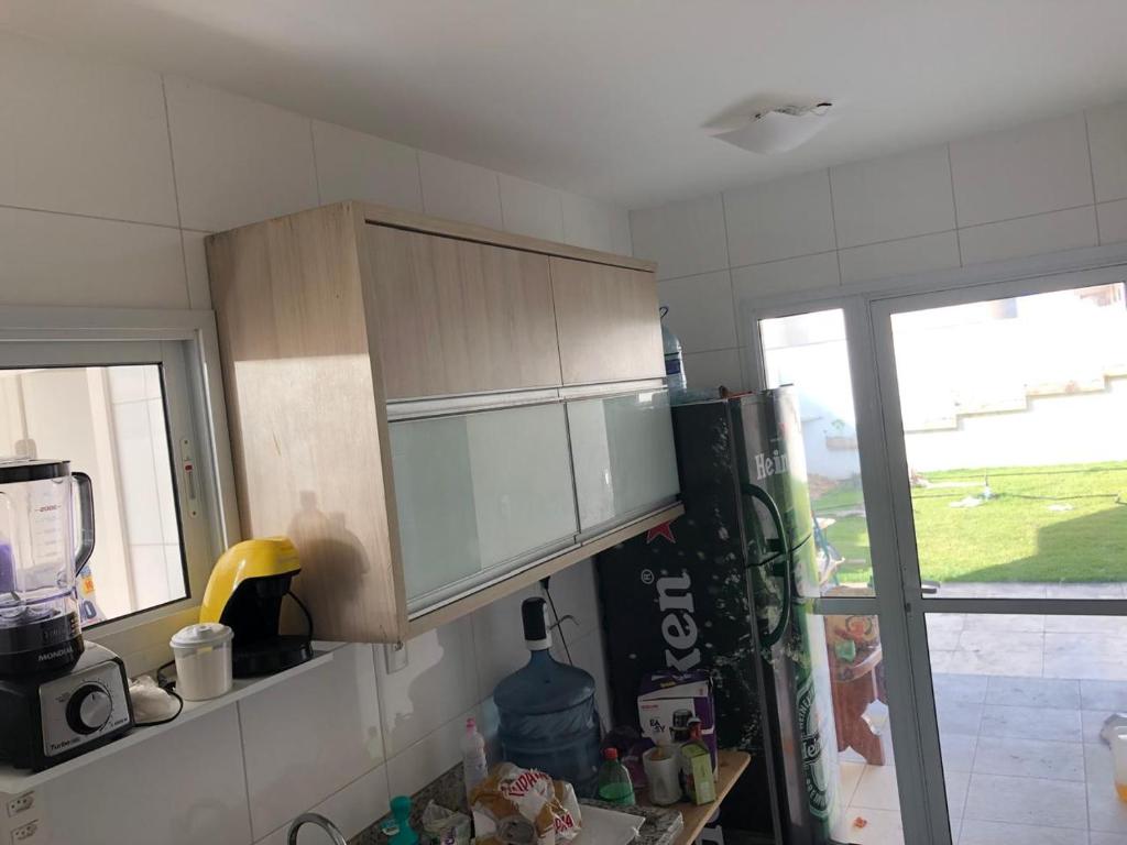 eine Küche mit Holzschränken und einem Kühlschrank in der Unterkunft CASA CONDOMINIO COSTA PARADIZO 3 Quartos in Barra dos Coqueiros