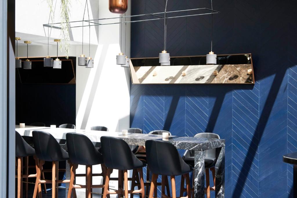 Perpetual Elysée Montaigne في باريس: غرفة طعام بجدران زرقاء وطاولة وكراسي