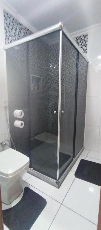 Un baño con ducha de cristal con inodoro. en Casa aconchegante, en Río de Janeiro