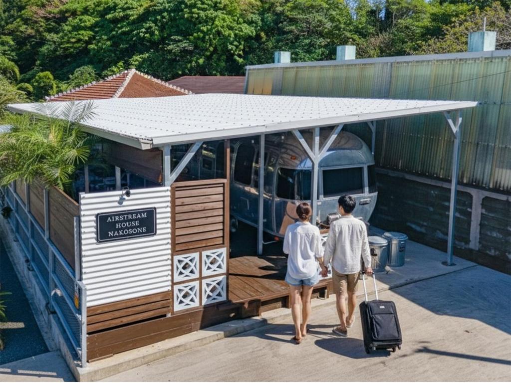 two people walking out of a tiny house at Air Stream House Nakasone in Nakijin