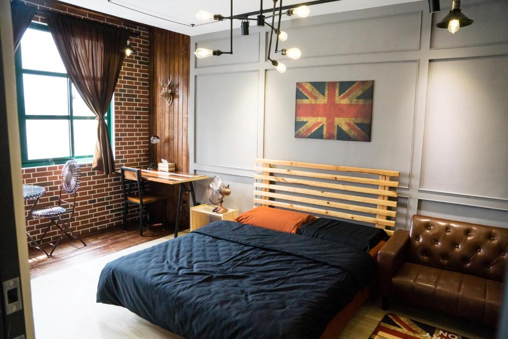 a bedroom with a bed and a chair in it at Baker Street London Style Inn in Tainan