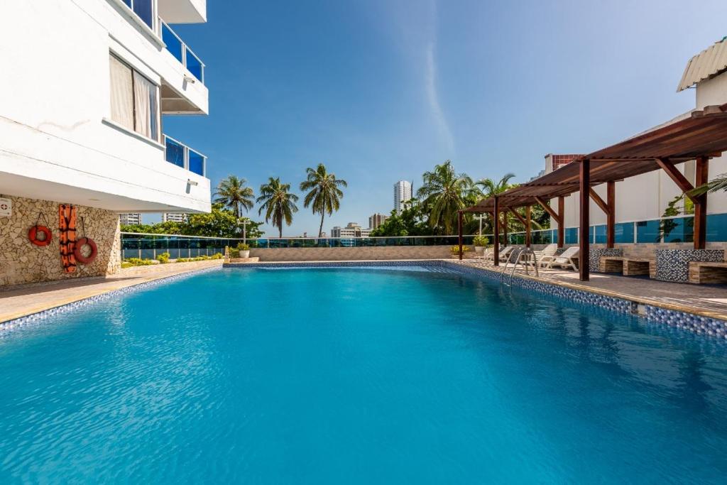 een groot blauw zwembad naast een gebouw bij Apartamento bonito en Cartagena ,el laguito bocagrande con vista al mar in Cartagena