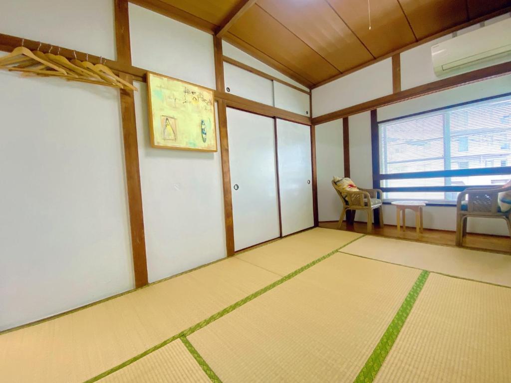 ein leeres Zimmer mit einem Tisch, Stühlen und einem Fenster in der Unterkunft KAMEYA HOUSE ENOSHIMA - Vacation STAY 01325v in Fujisawa