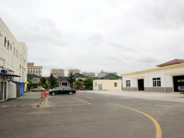 a parking lot with a car parked in a parking lot at Jinjiang Inn Taizhou Xinghua Dainan Town Government in Taizhou