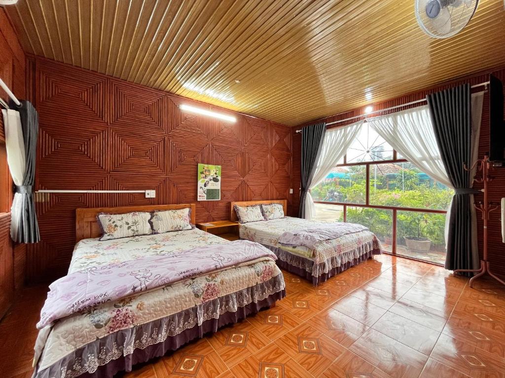 a bedroom with two beds and a large window at Ha Giang Eco Bungalow in Ha Giang