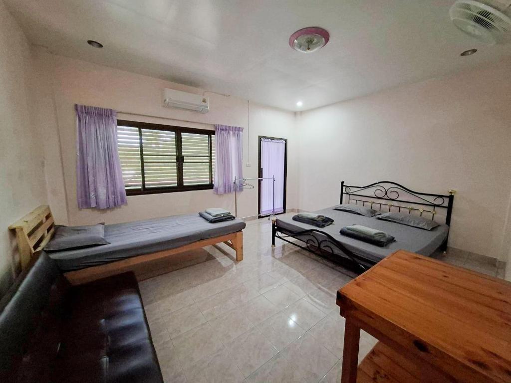 a room with a bed and a table and a couch at Padang Besar Border Private room & Hostel in Sathani Padang Besa