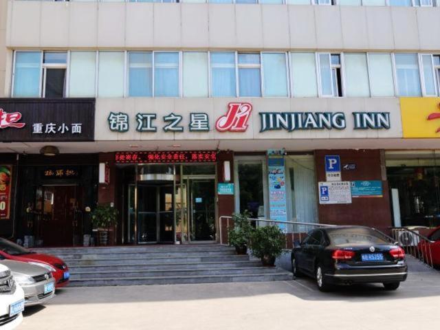 budynek z samochodem zaparkowanym przed nim w obiekcie Jinjiang Inn Yantai Wanda Plaza Huanshan Road w mieście Yantai