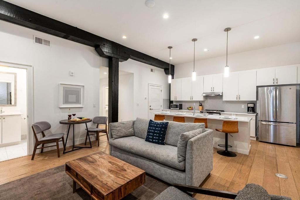 a living room with a couch and a kitchen at The Saddlery - Headliner - Walk to Broadway in Nashville