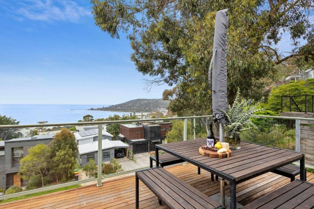 Una mesa de madera en una terraza con vista al océano. en Horizon Views, en Lorne