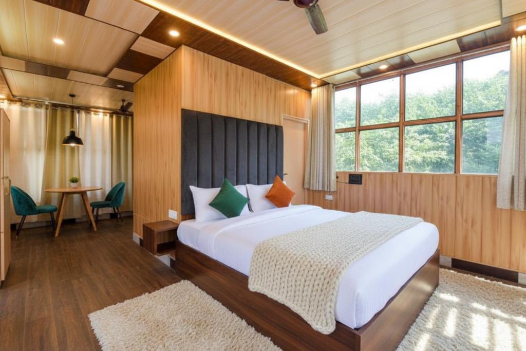 德拉敦The Homely Homestay Near Pacific Mall Dehradun的一间卧室，里面有一张大床和一张桌子。