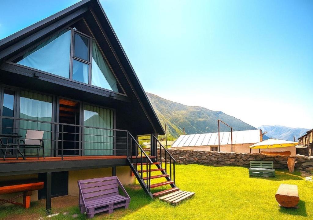 卡兹贝吉Misty Valley的一座房子,有楼梯通往房子的前面