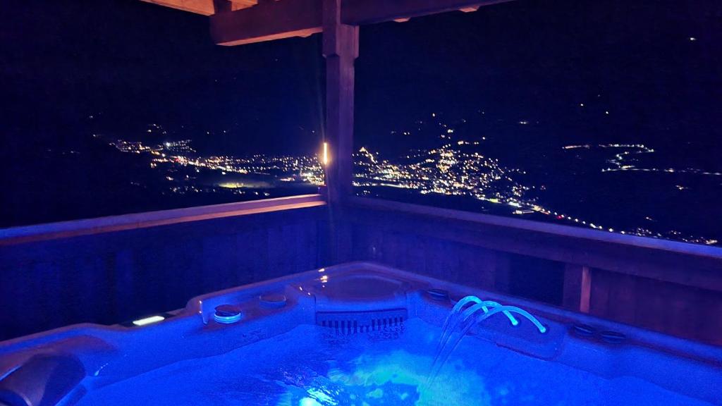 Una bañera con vistas a una ciudad de noche. en Ferienwohnung La-Wurm mit privatem Whirlpool, en Hart im Zillertal