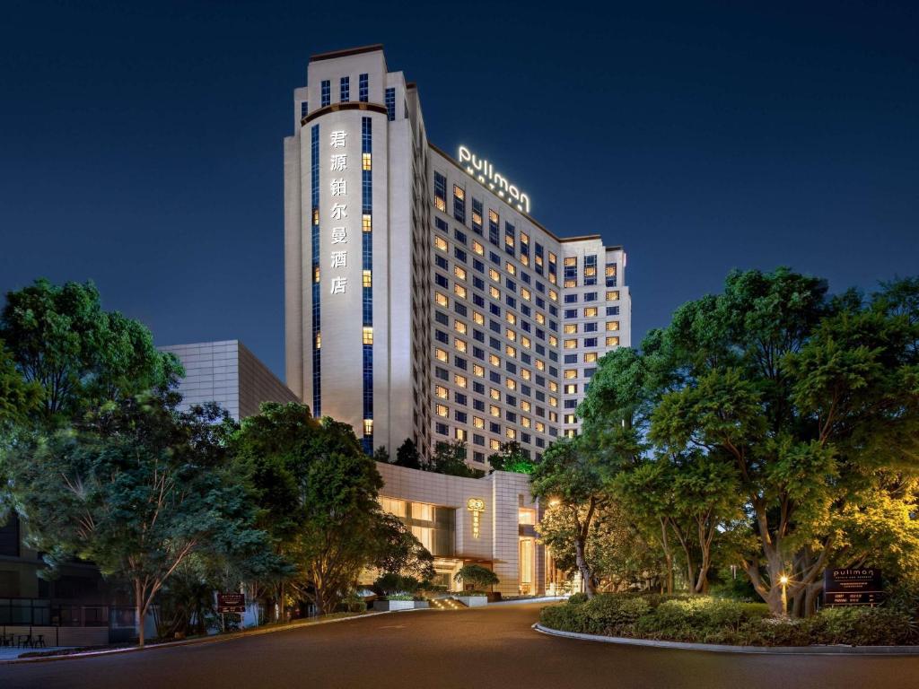 a large hotel building at night with a street at Pullman Dongguan Changan in Dongguan