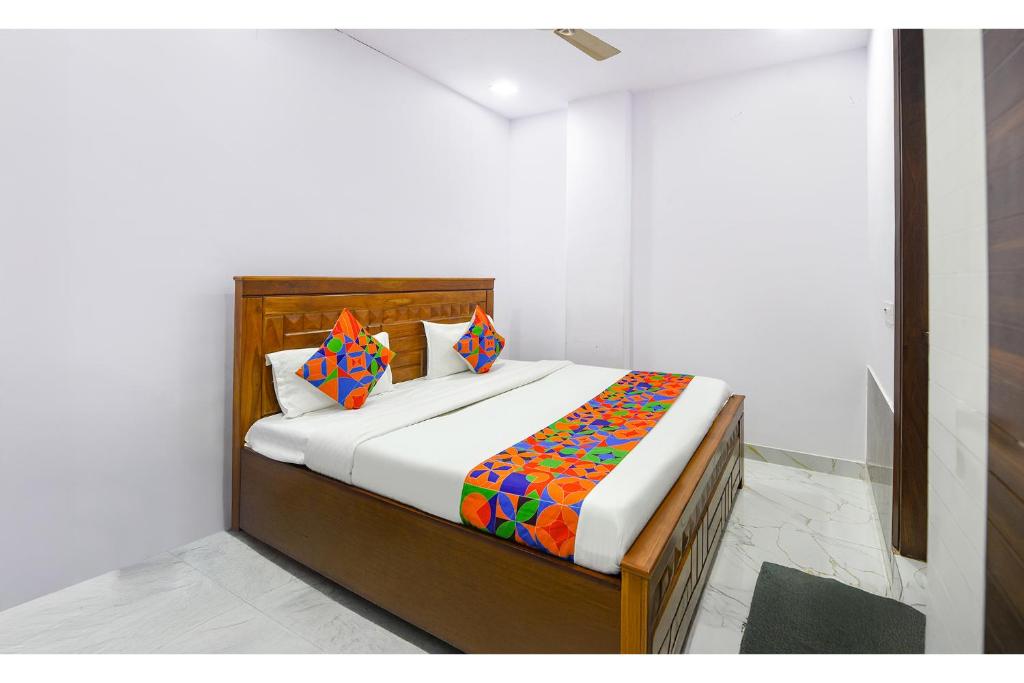 a bed in a white room with at Fabhotel Cosy Rooms - Near Embassies, DU South Campus in New Delhi