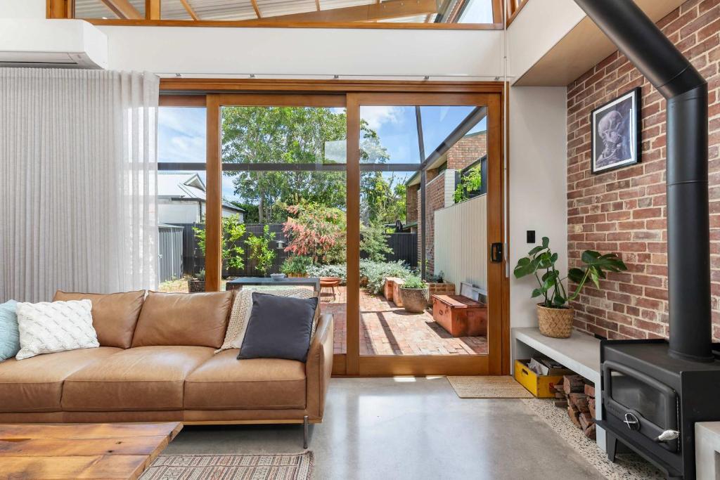 un salon avec un canapé et une cheminée dans l'établissement The Foundry on McLaren - Urban CBD Retreat, à Adélaïde