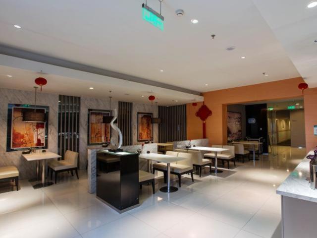 um restaurante com mesas e cadeiras num quarto em Jinjiang Inn Shanghai Hongqiao Hinge Tianshan West Road em Xangai