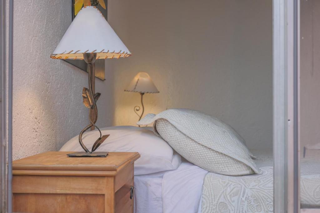 1 cama con 2 almohadas y una lámpara en una mesa en Cabañas La Ernestina, en Villa Carlos Paz