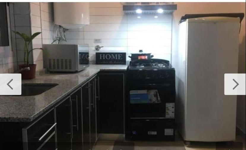 eine Küche mit Herd und Kühlschrank in der Unterkunft Apart Duclout Monte Grande a 15 minutos del Aeropuerto in Monte Grande