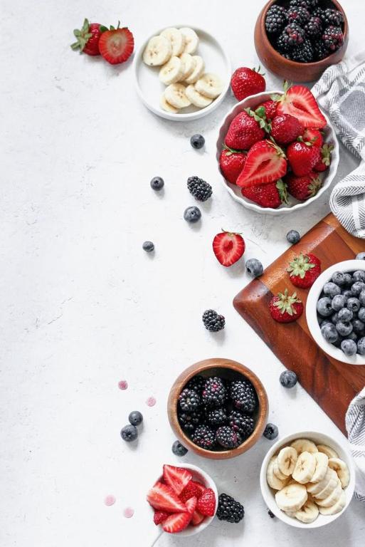 Una mesa con cuencos de frutas y cuencos de bayas. en Light Vesper Premium Hotel & Sky Bar, en Ho Chi Minh