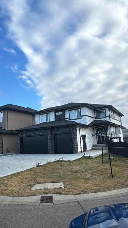 ein großes weißes Haus mit zwei Garagen in der Unterkunft Airlux in Nisku