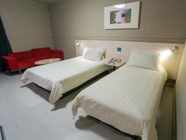 Habitación de hotel con 2 camas y sofá rojo en Jinjiang Inn Changzhou West Xinqiao en Changzhou