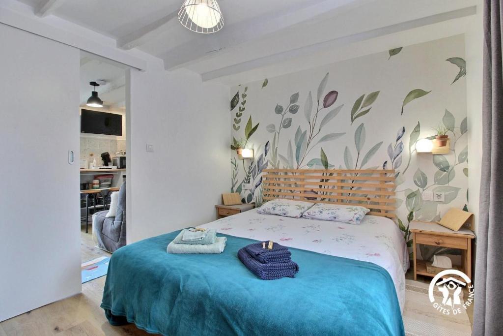 a bedroom with a bed with a blue blanket at Le tigite b&b in Saint-Jean-la-Poterie