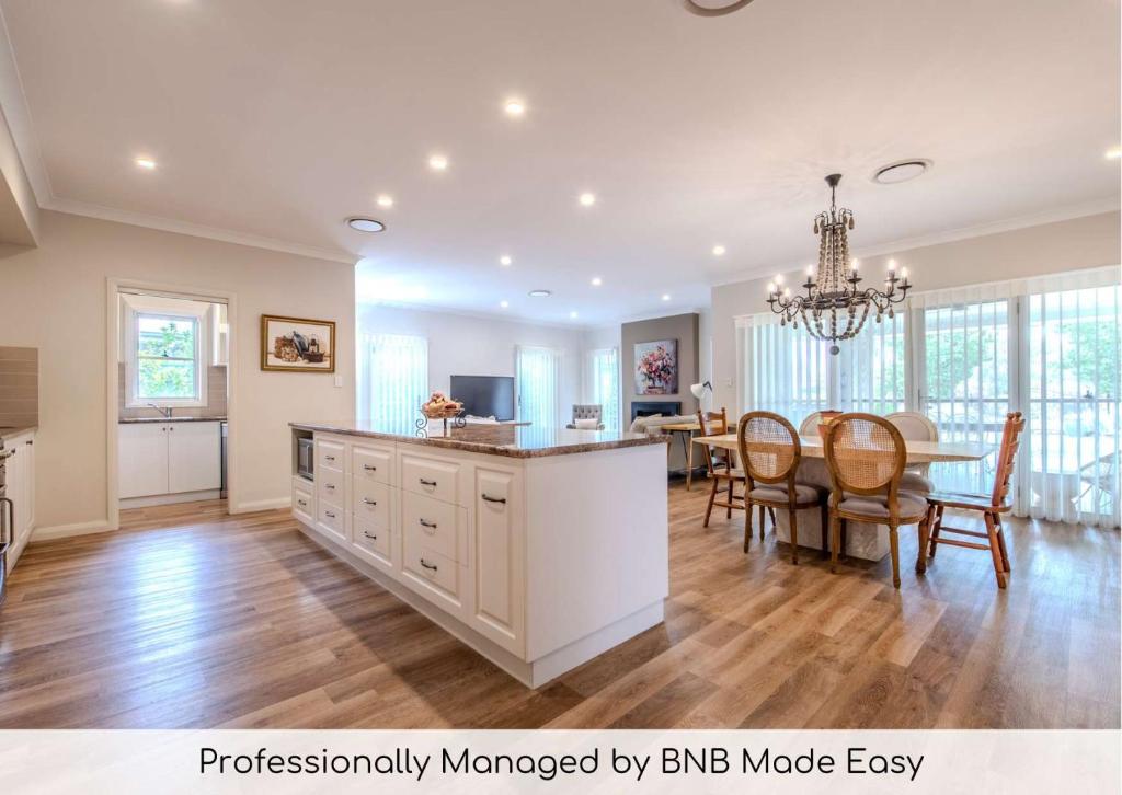 una cucina e una sala da pranzo con tavolo di Lakeside on Southlakes - Family Entertainer a Dubbo
