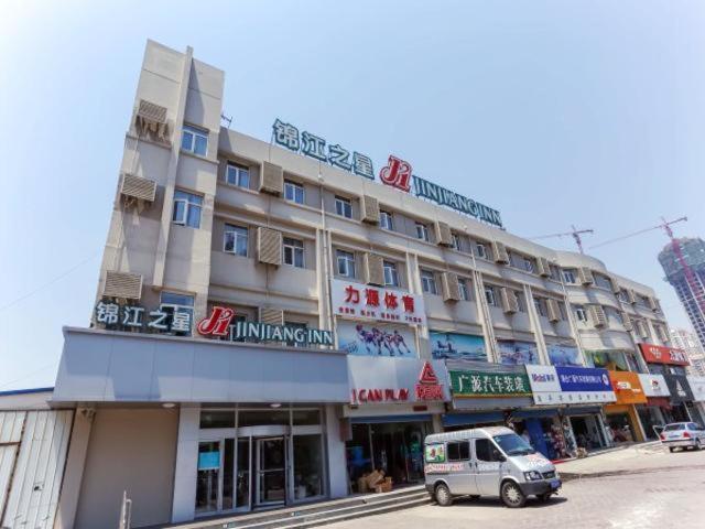 a building with a car parked in front of it at Jinjiang Inn Yantai Fushan District Fuhai Road in Yantai