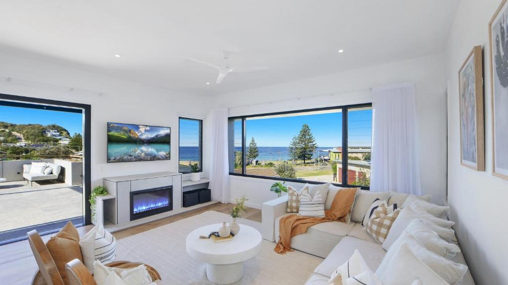 a living room with a couch and a fireplace at Omaroo House - Views Over Copa Beach in Copacabana