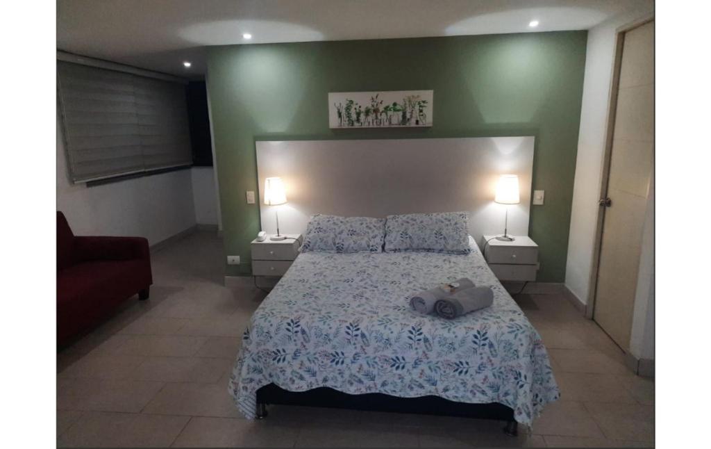 Un dormitorio con una cama grande con dos mesitas de noche. en ApartaSuite 2 a 3 personas cerca club campestre, en Medellín